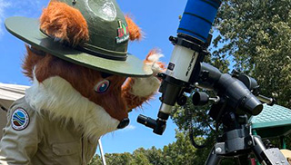 ፓርከር ሬድፎክስ በቴሌስኮፕ ይመለከታል